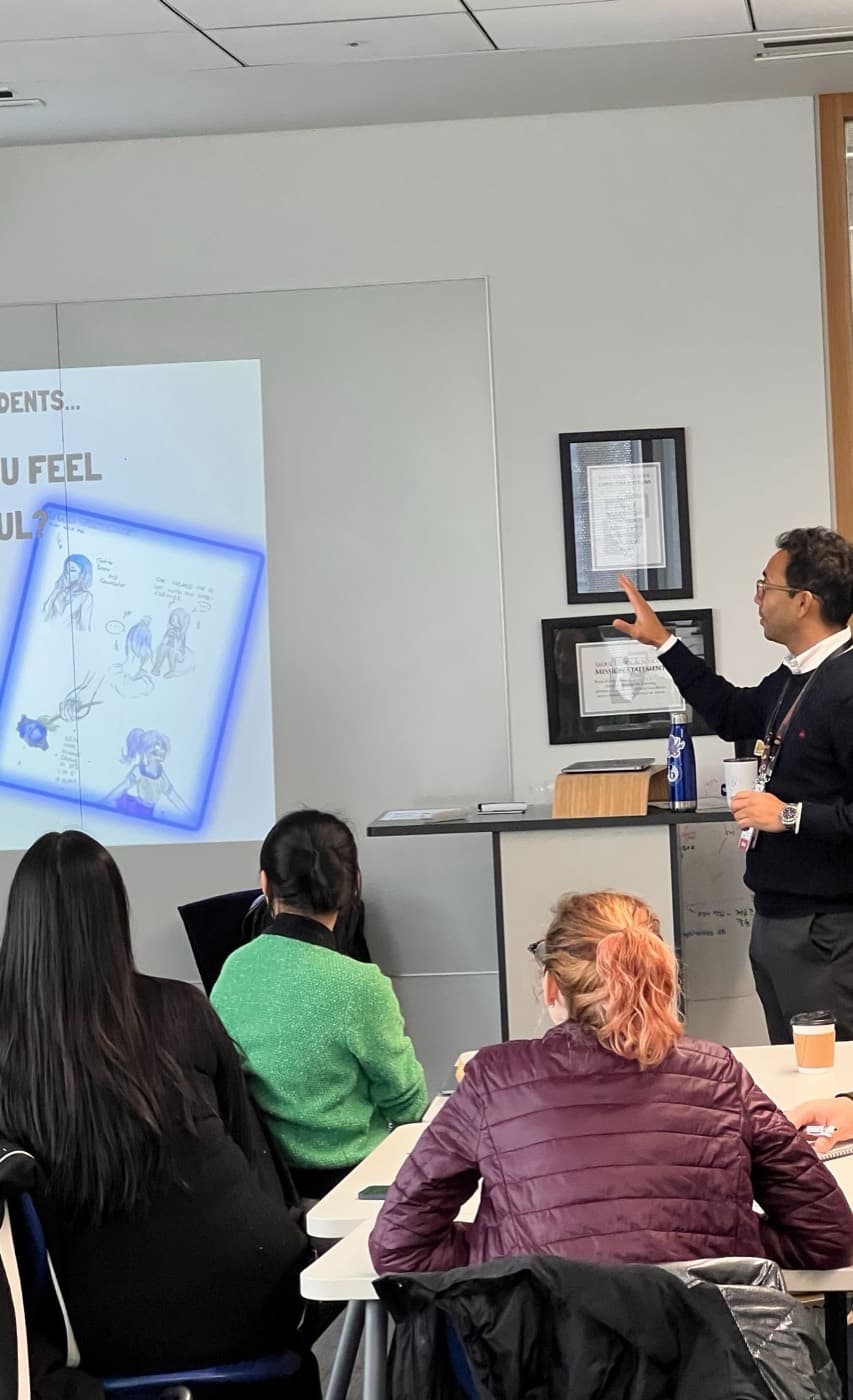 Rafael presenting a slide to a seated audience of educators.