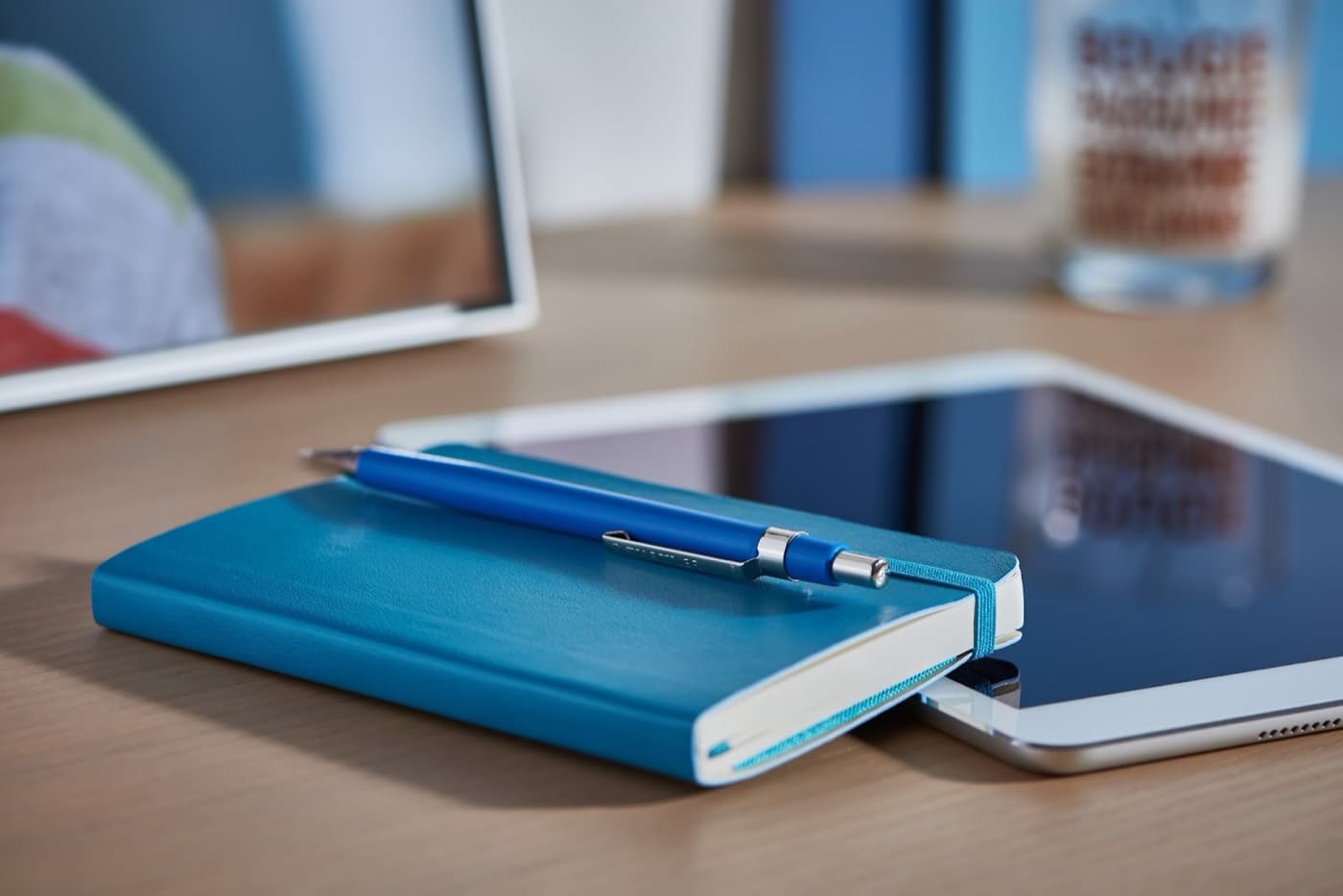A notebook and tablet on a desk.